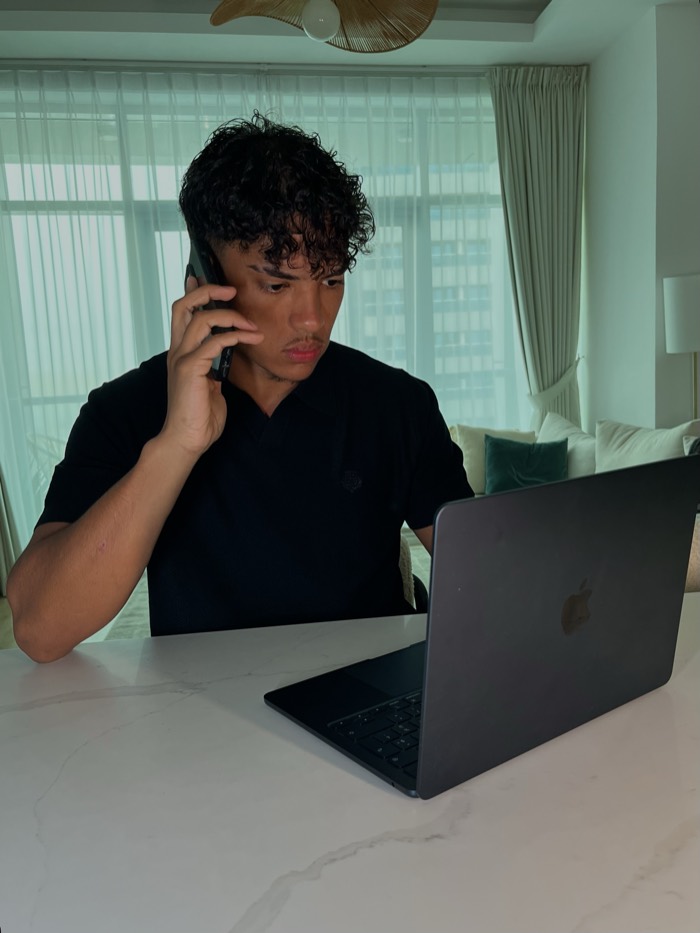 Le fondateur de CrediElevate au téléphone, assis devant son MacBook.
